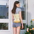 Model carrying a Mini Cloud Bag in cream yellow as crossbody, ideal for city walks and gifting.