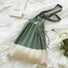 Green and cream accordion foldable knitted polyester bag with shoulder straps.
