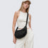 Model wearing a black lightweight nylon crescent sling bag as crossbody, showcasing the effortless urban style.