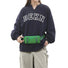 Model wearing the green airy stride mini belt bag at the waist over a sweatshirt.
