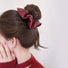 Model wearing an Ancora Red Leather Scrunchie, great for everyday styling and gifting.