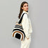 Model carrying a Arc Line Knitted Bag in black and khaki, easy for commuting and weekends.