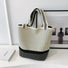 Cream-colored bucket bag with black dotted and striped artistic patterns.