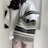Model carrying the white and black artistic pattern bucket bag over the shoulder.