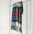 Flat lay of Autumn Ember Plaid Scarf in green and red, easy for travel packing and gifting.