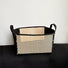 Folded view of Black fabric and natural woven bamboo foldable storage basket with handles.
