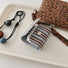 Flat lay of Beaded Melody Wrap Airpods Case Cover with the separated strap.