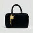 Yellow Big Eyed Stars bag charm hanging on a black bag, great for winter looks and travel days.