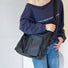 Model styling a black multi-pocket crossbody bag, perfect for showcasing personality in streetwear fashion.