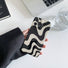 Model holding Black Wave Phone Case. Sleek wave-texture finish in durable acrylic, perfect for modern edgy fashion.