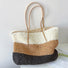 Angled view of Bohemia straw tote bag with horizontal stripes.
