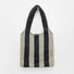 Close-up of Wool blend knit bag with bold black and beige vertical stripes and a shoulder strap wool shoulder bag.