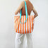Flat lay of Bold Color Striped Tote Bag in orange, ideal for errands and gifting.