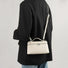 Model carrying a white bag as crossbody, easy for commuting and weekends.