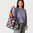 Model wearing a brown suede hobo bag with large blue polka dots, highlighting the slouchy hobo silhouette