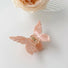 Flat lay of butterfly hair claw in pink, great for everyday styling and gifting.