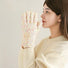 Model wearing cream candy-dot knit gloves with multicolor raised dots; soft knit for cold-weather outings.