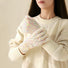 Model wearing cream candy-dot knit gloves with multicolor dot texture; cute accessory for chilly days.