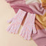 Pink candy-dot knit gloves with raised dot texture and ribbed cuffs, laid on a scarf; cozy winter styling.