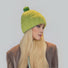 Side view of model wearing Candy Knitted Pompom Beanie. Playful 3D pompom in soft blend.