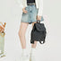 Model carrying a black Check Mate Mini Backpack handheld, ideal for city walks and gifting.