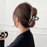 Model wearing checkerboard hair claw in line shape, easy for workdays and special occasions.