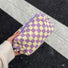 Hand-held purple checkered knit bag; showing the premium knit texture and compact size for urban daily use.