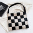 Black and white checkered woven PU leather bag shown flat, structured design perfect for organizing tablets and files.