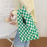 Model wearing the green and white checkered woven tote bag for a minimalist aesthetic.