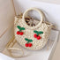 Flat lay of beige Cherry Rattan Straw Bag, great for everyday carry and travel.