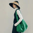 Model carrying a green bag on the shoulder, easy for commuting and weekends.