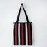 Folded view of Chromatic Stripe Knitted Bag in black and red, easy for commuting and weekends.