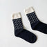 Flat lay of Classical Wave Rhythm Socks in black, great for daily wear and lounging.