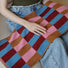 Model holding a Color Game Plaid Face Towel in pink-blue, ideal for beach days and poolside lounging.