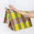 Model holding a Color Game Plaid Face Towel in yellow-green, ideal for beach days and poolside lounging.