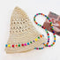 Flatlay view of the straw hat showing the removable beaded cord on a white background.