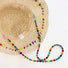 Close-up interior view of straw hat, showcasing detachable beaded cord and drawstring for adjusting head circumference.