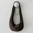 Dark brown corduroy crescent bag showcasing its soft ribbed texture.