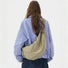 Back view of the model carrying the khaki corduroy crescent crossbody bag.