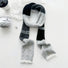 Flat lay of Cozy Patch Skinny Scarf in gray, great for office layering and commuting.