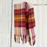 Flat lay of Crimson Meadow Plaid Scarf in burgundy and maroon and red, easy for travel packing and gifting.