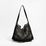 Angled view of Black crochet shoulder bag with a long leather strap and cotton rope net design, easy for commuting.