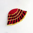 Detailed top view of the red bucket hat, with yellow and black cross striped pattern.