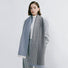 Model wearing a striped scarf in gray and blue , great for office layering and commuting.