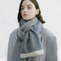 Model wearing a striped scarf in gray and blue, ideal for daily wear and travel.