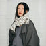 Model wearing soft, dual-sided wool blend scarf in white with brown and black aurora texture in gray, ideal for daily.