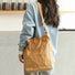 A person wearing a tan kraft-paper-look tote bag as shoulder bag, showcasing a minimalist chic style.