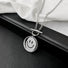 Flat lay of silver titanium steel emoti spin necklace on a dark surface