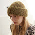 Woman wearing fluffy knitted thick beanie in brown and lime green, crafted for maximum thermal insulation.