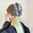 Model wearing a blue fluffy striped hair claw, great for date nights and events.